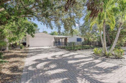 a house with a garage in the middle of a driveway at Toes in the Water - Pool Home on Siesta Key in Siesta Key