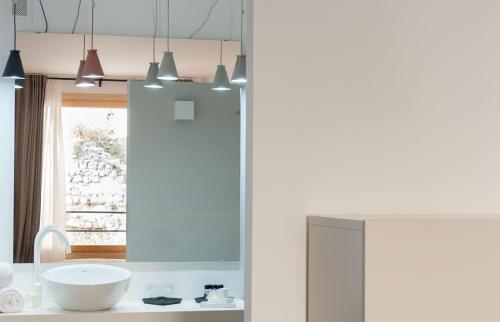 a white bathroom with a sink and a window at Casa Del Castell in Móra d'Ebre