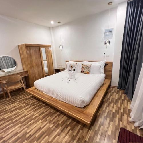a bedroom with a large white bed with a desk at Stingless Villa in Ban Ket Ho