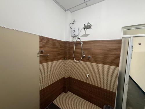a shower in a bathroom with a wooden wall at Green Bird in Mirissa