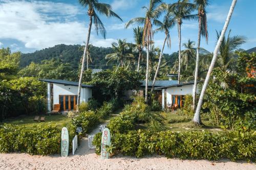 ein Haus am Strand mit Palmen in der Unterkunft Bamboo Surf Beach in San Isidro