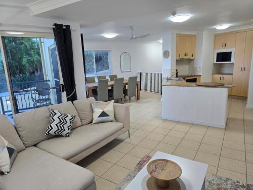 a living room with a couch and a kitchen at Villa Mar Colina in Yeppoon