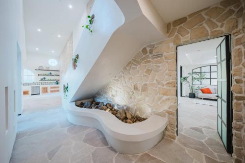 a stone fireplace in a living room with a stone wall at Mintcello Estate in Malibu