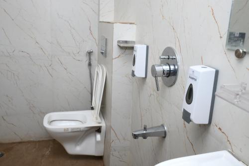 ein weißes Badezimmer mit Toilette und Waschbecken in der Unterkunft Xylem Sea Side Resort in Puri