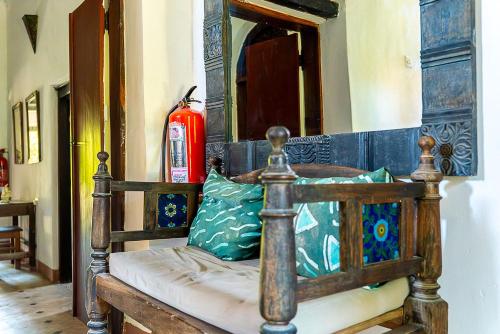 a wooden bed in a room with a fire extinguisher at Ella's Swahili House in Bagamoyo
