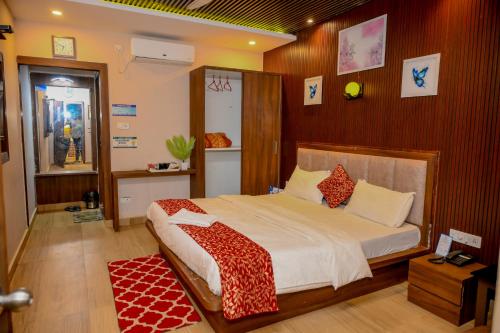 ein Schlafzimmer mit einem Bett mit einer rot-weißen Decke in der Unterkunft Xylem Sea Side Resort in Puri