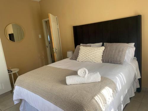 une chambre avec un grand lit avec deux serviettes dessus dans l'établissement Cozy Haven in Manzini, à Manzini