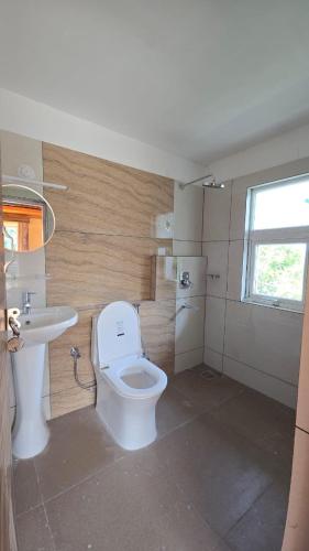a bathroom with a toilet and a sink at Tapas in Champawat