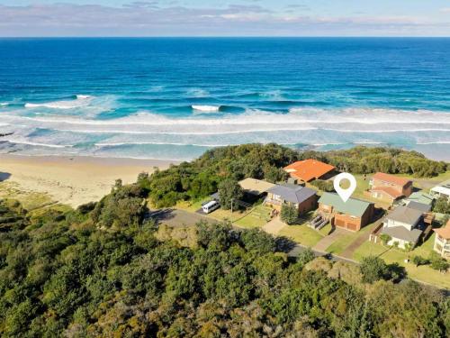een luchtfoto van een huis naast een strand bij Rennies Beach Escape "Carinya" in Ulladulla