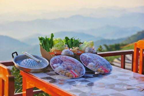 een tafel met vier borden eten erop bij เต็นท์กระโจม - Raiwassana Baandoy in Ban Dong