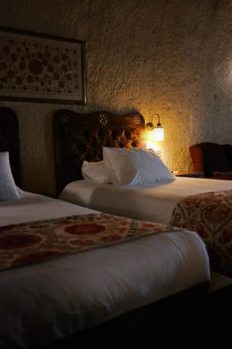 a hotel room with two beds and a lamp at Dreams Cave Hotel in Ortahisar