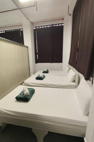 a room with two beds with towels on them at Franca Arcade near Quezon City Circle in Manila