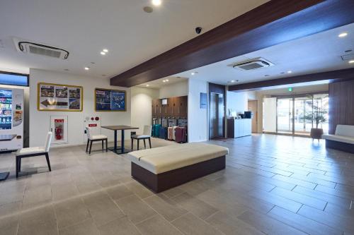 a lobby with a couch and a table and chairs at Hotel Lexton Kagoshima Annex in Kagoshima