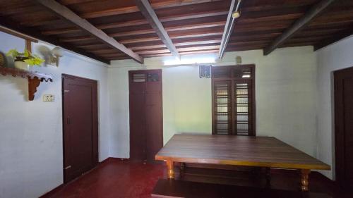 Zimmer mit einem Holztisch in einem Zimmer in der Unterkunft Idam Homestay - Entire 3 Bedroom Holiday Home in Idukki