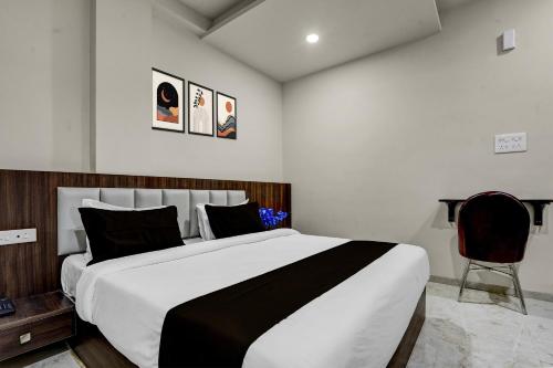 a bedroom with a large bed and a chair at Townhouse Ganesh Tekdi Temple Nagpur in Nagpur