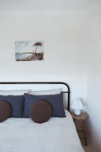 a bedroom with a bed with a picture on the wall at Gills in Murdunna