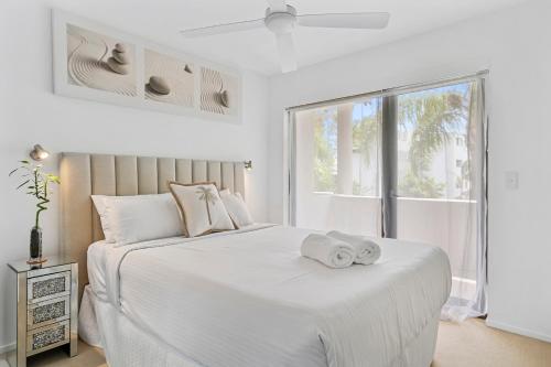 En eller flere senge i et værelse på St Tropez 8 - Waterfront Retreat with Rooftop Spa & Sauna