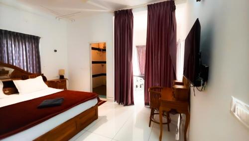 a bedroom with a bed and a television in it at moonlight palace private pool villa vagamon in Vagamon