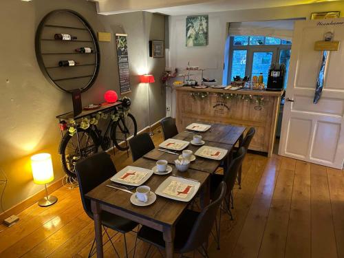 een eetkamer met een tafel met stoelen en een spiegel bij L'Ancienne Boulangerie in Durbuy