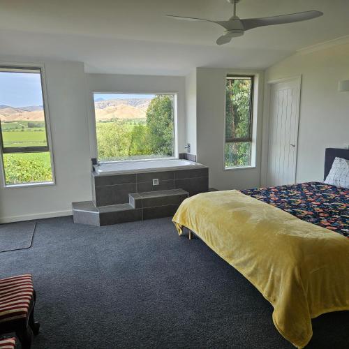 a bedroom with a bed and a sink and two windows at Fairhall view in Marlborough Airport