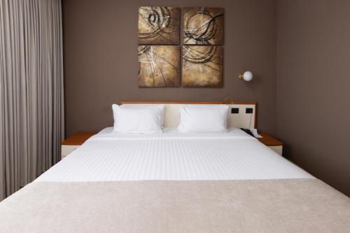a bedroom with a large white bed with two pillows at Best Western Plus Congress Hotel Yerevan in Yerevan
