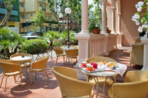 a patio with tables and chairs on a balcony at Hotel Villa Luigia in Rimini