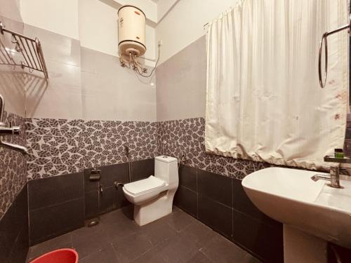 une salle de bains avec toilettes et lavabo dans l'établissement Majestic Heights Hotel, à Jaipur