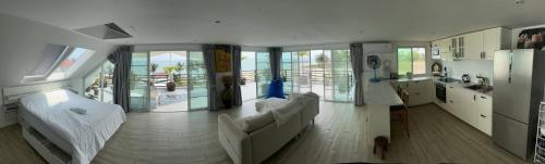 een woonkamer met 2 witte banken en een keuken bij Romantic Beachside Retreat with Breathtaking Views in Ban Nong Hoi Siap