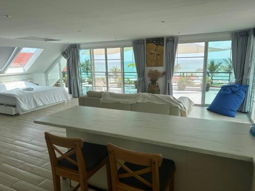 een grote woonkamer met een bed en een tafel bij Romantic Beachside Retreat with Breathtaking Views in Ban Nong Hoi Siap