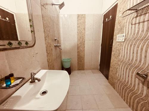 une salle de bains avec un lavabo blanc et une douche dans l'établissement Majestic Heights Hotel, à Jaipur