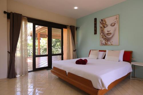 een slaapkamer met een groot wit bed en een glazen schuifdeur bij Nature's Hill side Phana House in Ban Nong Chaeng