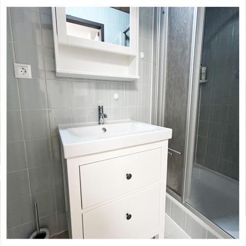 a bathroom with a white sink and a shower at Studio Homebase in Spittal an der Drau
