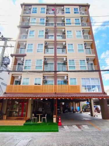 a tall building with a balcony and tables in front of it at SNOW HOUSE Buriram in Buriram