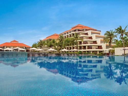 een uitzicht op een resort met een groot zwembad bij Pullman Danang Beach Resort in Da Nang