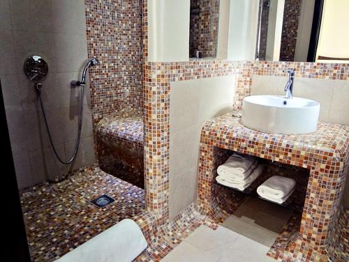 a bathroom with a sink and a shower at Al Raya Suites Hotel in Manama