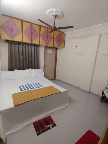 En eller flere senge i et værelse på Ambai Guest House