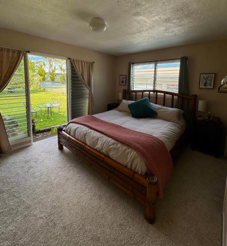 a bedroom with a bed and a large window at Master Suite with Private Bath 15 min drive to beach in Hilo