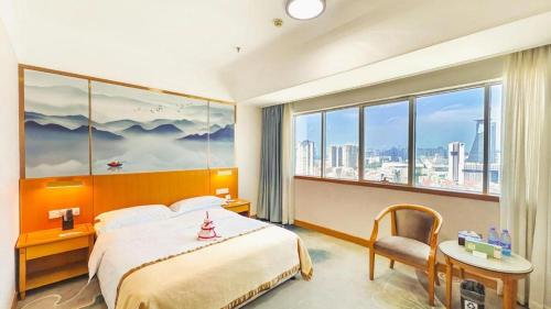 厦门Xiamen Jingmin Central Hotel的一间酒店房间，里面有一张床和一扇大窗户。