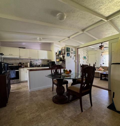 a kitchen and dining room with a table and chairs at Master Suite with Private Bath 15 min drive to beach in Hilo