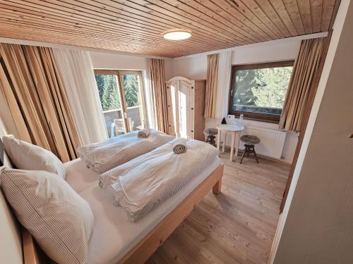 una camera da letto con due letti, un tavolo e una finestra di Pension Panorama Warth a Lechleiten