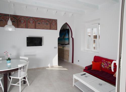 a living room with a red couch and a table at Puerta la Mar in Tarifa