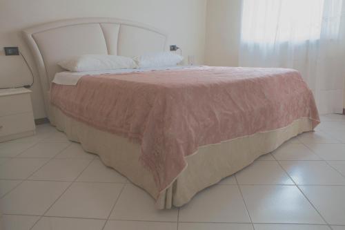 カスティリオーン・フィオレンティーノにあるCasa Traquandiのベッドルーム1室(ピンクの毛布付きの大型ベッド1台付)