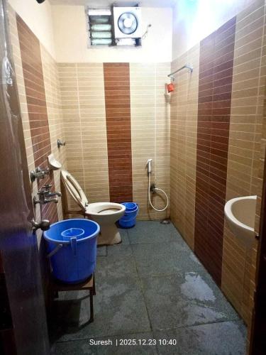 a bathroom with a toilet and a sink and a clock at Challa Residency in Rājahmundry