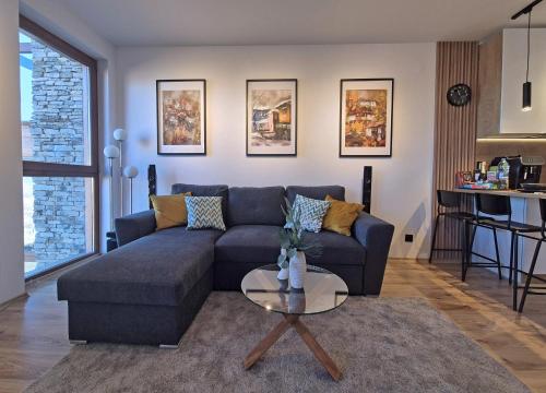een woonkamer met een blauwe bank en een tafel bij Bansko St Ivan Rilski Residences in Bansko