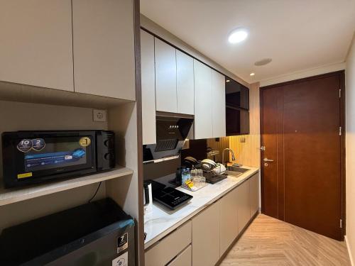 eine kleine Küche mit einer Mikrowelle und einer Theke in der Unterkunft Modern Luxury Studio at Pollux by Superstay in Batam Center
