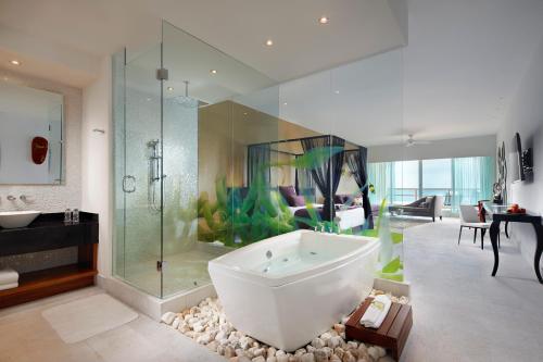 baño con bañera grande y acuario en Senses Riviera Maya by Artisan - All inclusive-Adults only, en Puerto Morelos