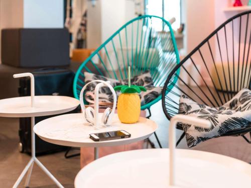 twee stoelen en een tafel met een ananas erop. bij Ibis Styles Nice Centre Gare in Nice