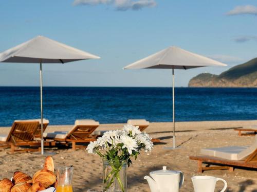 een tafel met brood en bloemen op het strand bij Sofitel Tamuda Bay Beach And Spa in M'diq