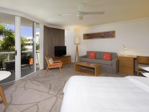 努萨角Elysium Noosa Resort - MGallery Collection的一间酒店房间，里面有一张床和一张沙发