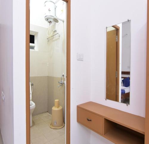 ein Badezimmer mit Waschbecken und Spiegel in der Unterkunft Pondicherry Comfort Rooms in Puducherry